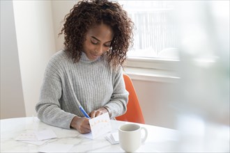 Woman writing in card at table