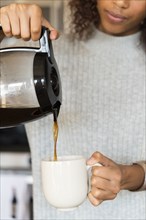Woman pouring cup of coffee
