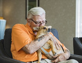 Senior man holding dog