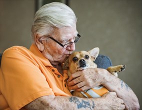 Senior man kissing dog