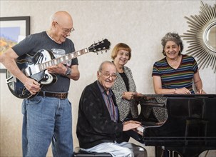 Smiling senior people playing instruments