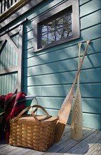 Oars and picnic supplies by blue wall