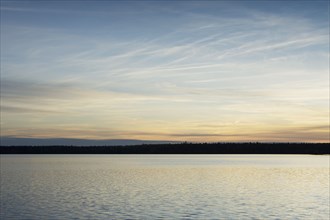 Silhouette of trees and lake at sunset