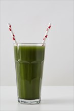 Green juice in cup with straws