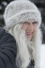 Smiling woman wearing hat in snow