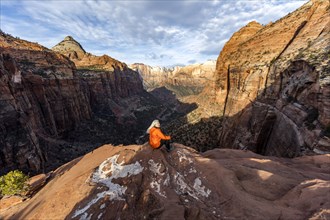 Woman sitting on cliff at Zion National Park in Utah, USA