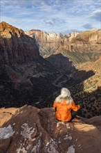 Woman sitting on cliff at Zion National Park in Utah, USA