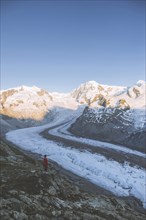 Woman standing on rock by Gorner Glacier in Valais, Switzerland