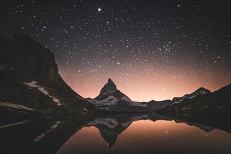 Matterhorn mountain and lake at night in Valais, Switzerland