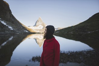 Woman standing by Matterhorn mountain and lake in Valais, Switzerland