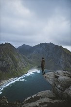 Man standing on cliff at Ryten mountain in Lofoten Islands, Norway