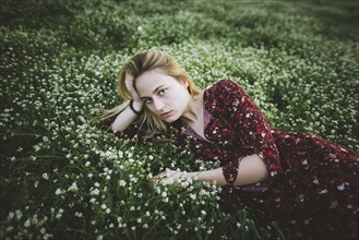 Woman wearing dress lying in meadow