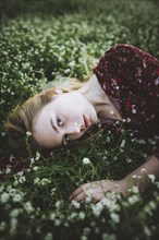 Woman wearing blouse lying in meadow