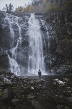 Man standing by Skjervefossen waterfall in Norway