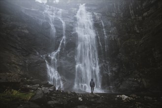 Man standing by Skjervefossen waterfall in Norway