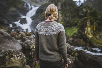 Woman wearing sweater by Latefossen waterfall in Vestland, Norway