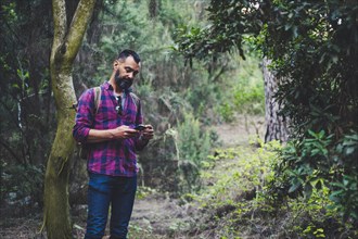 Man using smart phone in forest