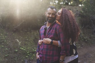 Smiling couple embracing in forest