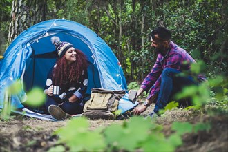 Smiling couple camping in forest