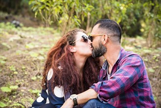 Couple kissing by trees