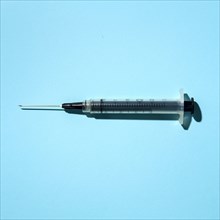 Syringe on blue background