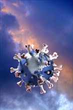 Model of globe in shape of Coronavirus floating against clouds