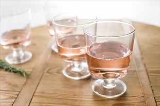 Glasses of rose wine on wooden table