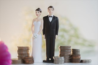 Bride and Groom cake toppers next to stacks of coins