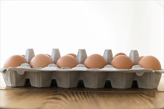 Carton of eggs on wooden table