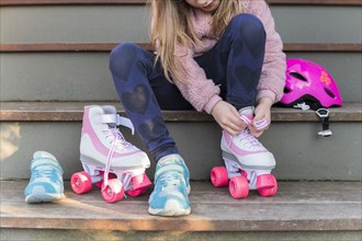 Girl tying the laces of her roller skates