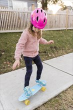 Girl skateboarding down a sidewalk