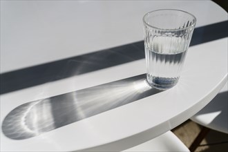Glass of water on table making shadows