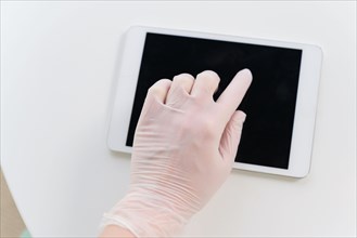 Hand in protective glove using tablet