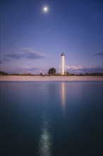 USA, Florida, Boca GrandeLighthouse reflecting in sea at night