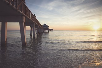 USA, Florida, Fort Myers Beach, Pier in sea at sunset