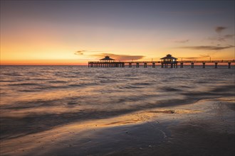 USA, Florida, Fort Myers Beach, Pier in sea at sunset