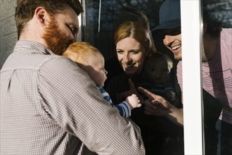USA, Georgia, Atlanta, Man with baby son (2-5 months) visiting family through window