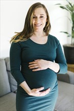 Portrait of pregnant woman touching belly