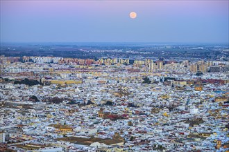Spain, Andalusia, Seville, Moonrise over cityscape