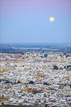 Spain, Andalusia, Seville, Moonrise over cityscape