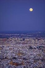Spain, Andalusia, Seville, Moonrise over cityscape