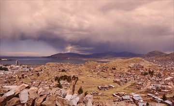 Peru, Sillustani, Storm clouds over village