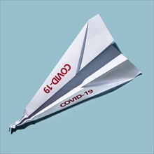 Studio shot of paper plane with Covid-19 sign