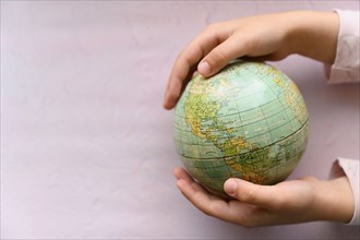 Close-up of girls (6-7) hands holding globe