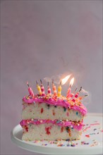 Slice of birthday cake with candles