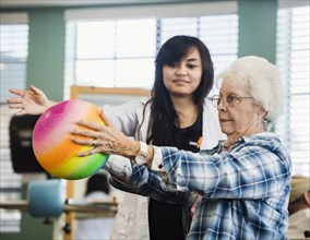 Senior woman exercising with therapist during physical therapy