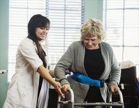 Senior woman exercising with therapist during physical therapy