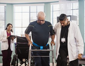 Senior man exercising with therapists during physical therapy