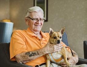 Senior man holding service dog