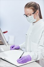 Female technician writing in notebook